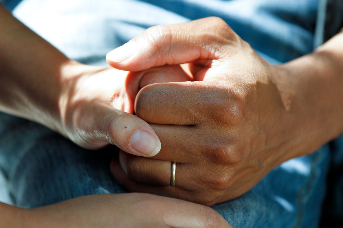 A caregiver holding a patient’s hand during a home visit